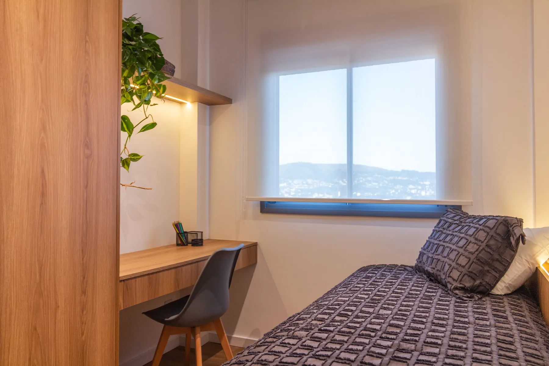 Segundo dormitório com bancada de estudo e vista para a cidade